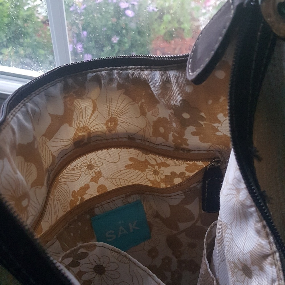 This is a 'Sak' Medium size off-white shoulder bag